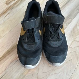 Girls black and gold Nike shoes